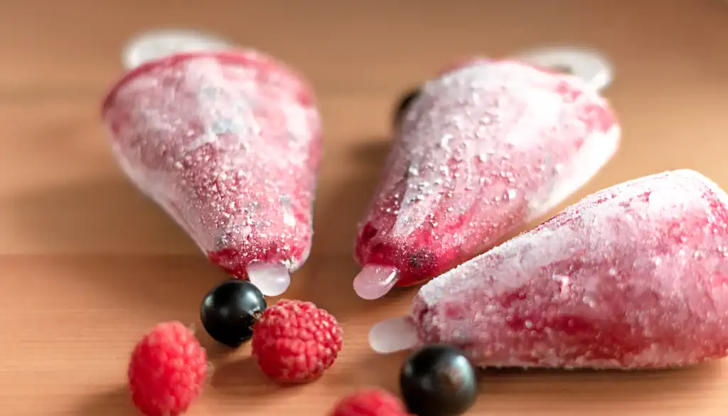 Ein stilvoller Eisbecher mit einer großzügigen Portion Erdbeereis, das durch die Zugabe von CBD-Öl eine einzigartige Note erhält. Das Eis ist übersät mit kleinen, glitzernden CBD-Kristallen, die im Licht schimmern. Umgeben von frischen Erdbeeren und einem dekorativen Hanfblatt, lädt dieses Dessert zum Genießen ein. Ein zartes Minzblatt fügt einen Hauch von Frische hinzu, während die Szene von einem warmen Sommerlicht erleuchtet wird.